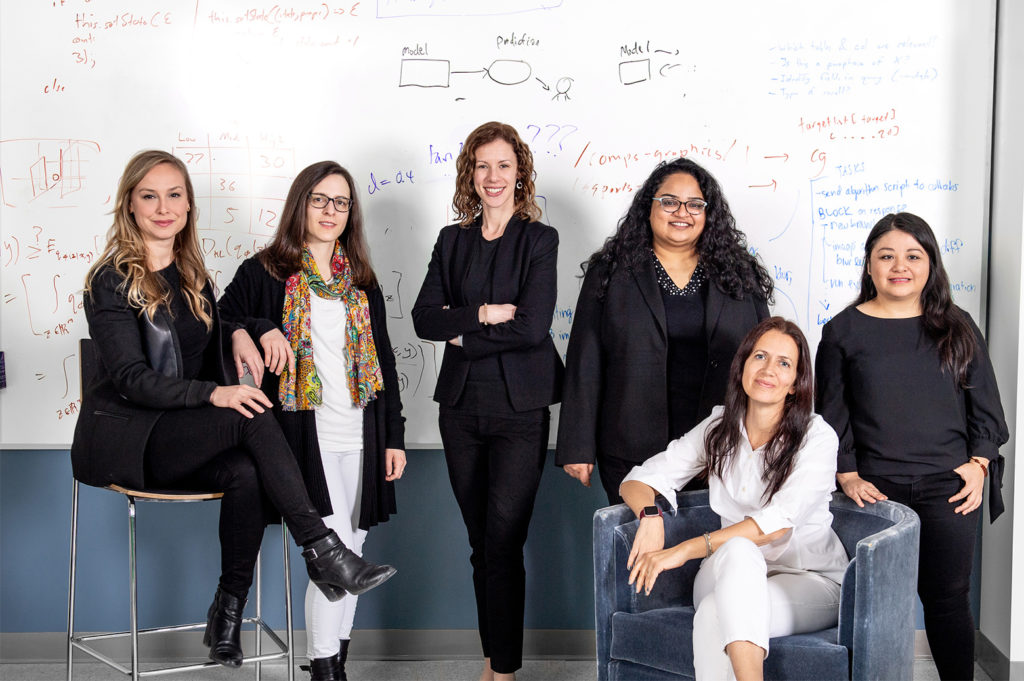 Six women faculty in a classroom
